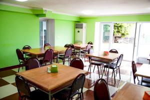 a restaurant with tables and chairs and green walls at Hotel "Qeti" in Shekhvetili