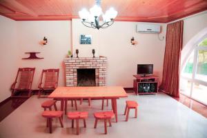 a dining room with a table and chairs and a fireplace at Hotel "Qeti" in Shekhvetili