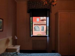 a bedroom with a window with a view of a building at villa berghinz in Venice-Lido