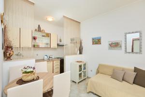 a kitchen and living room with a table and a couch at Studio Dolores-apartment by the sea in Maranovići