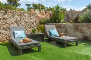 two chairs and a table in a yard with grass at Charmante Villa »InDa » in Bonifacio