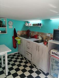 cocina con paredes azules y suelo a cuadros en Guest House Marina, en Tiflis