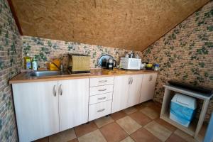 a kitchen with a sink and a brick wall at Pokoje Gościnne Martynka in Białogóra
