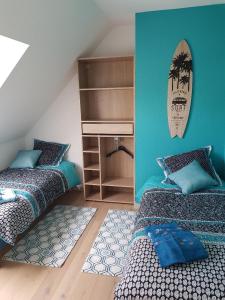 Duas camas num quarto com paredes azuis em charmante maison proche des alignements em Carnac