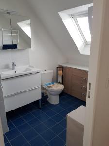 a bathroom with a toilet and a sink and a window at Gîte mon plaisir in Carnac