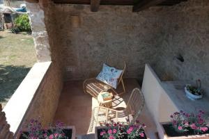 un patio con 2 sillas y una mesa con flores en Cal Niu, en Castillo de Aro