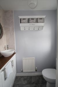uma casa de banho com um WC branco e um lavatório. em Harriers Grove House em Skegby