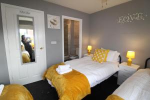 a bedroom with two beds and a mirror at Harriers Grove House in Skegby