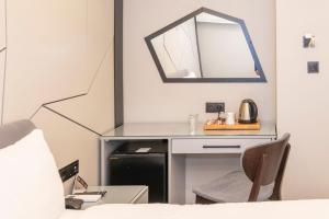 a bedroom with a desk and a mirror at White Corner Hotel in Istanbul
