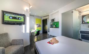 Zimmer mit einem Tisch und einem TV an der Wand in der Unterkunft 130 Rock Apartments in Tel Aviv