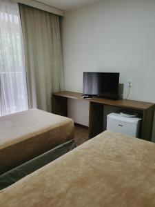 a hotel room with a television and a bed at Nobile Inn Via Premiere in Rio de Janeiro