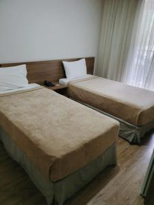 two beds in a room with two windows at Nobile Inn Via Premiere in Rio de Janeiro