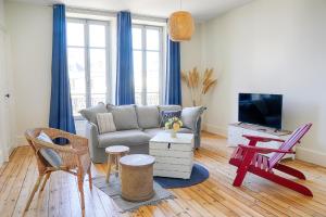 a living room with a couch and a tv at Résidence L'Aristide : Appartement Malo in Auray