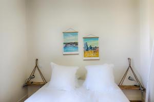 a bedroom with two white pillows and two pictures on the wall at Résidence L'Aristide : Appartement Malo in Auray