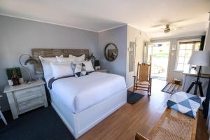 um quarto com uma cama branca, uma mesa e uma cadeira em Lighthouse Motel and Cottages em Bridgewater