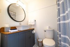 a bathroom with a sink and a toilet and a mirror at Lighthouse Motel and Cottages in Bridgewater