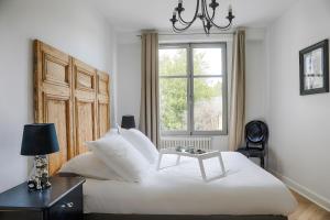 um quarto com uma grande cama branca e uma janela em Résidence L'Aristide Appartement Louison em Auray