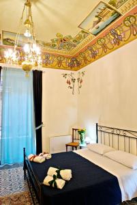 sypialnia z dużym łóżkiem i żyrandolem w obiekcie Domus Aurea w mieście Montalbano Elicona