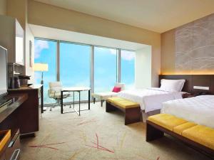 a hotel room with two beds and a desk and a table at Osaka Marriott Miyako Hotel in Osaka