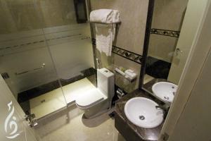 a bathroom with a toilet and a sink and a mirror at Rafa Homes in Riyadh