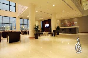 a lobby with chairs and a television in a building at Rafa Homes in Riyadh