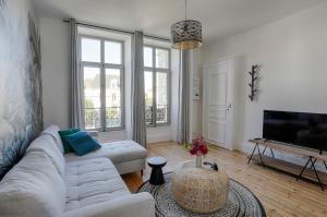 a living room with a couch and a table at Résidence l'Aristide : Appartement Naomi in Auray