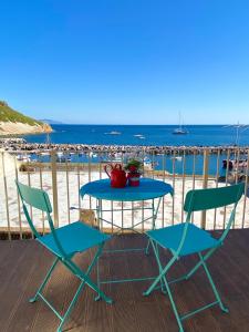 a table and chairs on a deck with the beach at "La Terrazza" Corricella in Procida