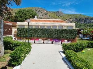 ein Gebäude mit Pflanzen und Blumen in einem Hof in der Unterkunft Rifa b&b in Gaeta