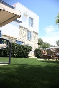a yard with chairs and a building in the background at Tepe Hotel in Alaçatı
