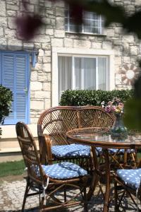 a wooden table with chairs and a table with flowers at Tepe Hotel in Alaçatı