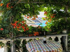 una bottiglia di vino seduta su un tavolo con fiori di Apartment Coral a Metajna