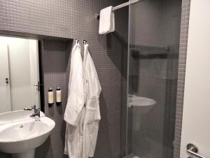 a bathroom with a shower and a sink and a shower at Souto Guest House in Braga