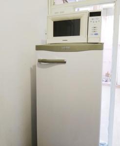 a microwave sitting on top of a refrigerator at Departamento Temporario Bahía Blanca pleno centro de la ciudad in Bahía Blanca