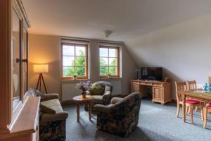 a living room with two chairs and a table at Berggasthof Koitsche im Naturpark Zittauer Gebirge in Bertsdorf