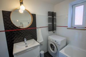 a bathroom with a washing machine and a sink at Apartament na Cysterskim Szlaku in Starzyno +16 photos