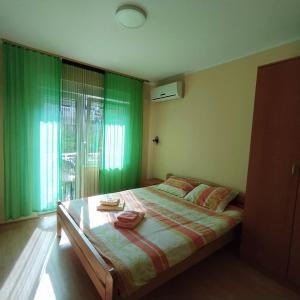 a bedroom with a large bed with green curtains at Apartmani Smiljanic Sokobanja in Soko Banja
