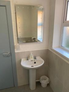 a bathroom with a sink and a mirror at Mill House Studio Apartment in Stranocum