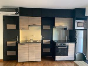a kitchen with white and black cabinets and a sink at Juan les Pins Joli T2 parking inclus! in Antibes