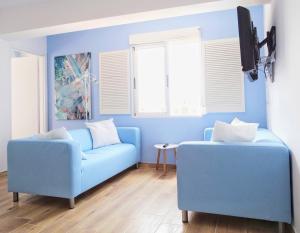 a blue living room with a blue couch and windows at La Grauera 5 planta sin ascensor in Gandía