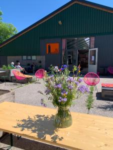 a vase of flowers on a table in front of a building at Het Lage Noorden in Marrum