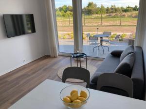 a living room with a couch and a bowl of fruit on a table at Dwa Morza domki całoroczne z ogrodem in Puck