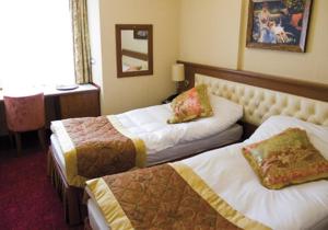 een hotelkamer met 3 bedden en een bureau bij Hotel Linda in Istanbul