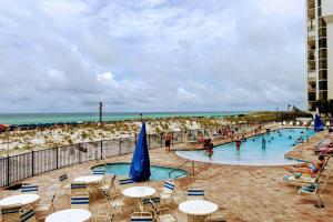 德斯坦的住宿－Beachfront, Oceanview, Pelican Beach Resort, 19th Floor，海滩上的游泳池,配有桌椅