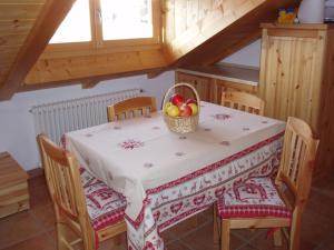 Una mesa de comedor con una cesta de fruta encima. en Agritur Melango, en Fondo 8 fotos más