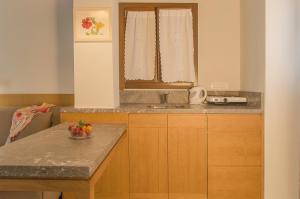 uma cozinha com um lavatório e um balcão com uma taça de fruta em Kalypso Studios & Rooms em Palaiochora