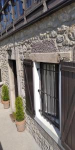 a stone building with two doors and potted plants at Casa de Aldea la Galeria in poo de Llanes