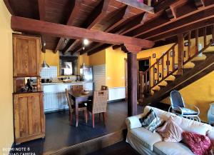 a living room with a couch and a table and a kitchen at La obra de Joaquin, tu rincón en el Bierzo alto in Folgoso de la Ribera