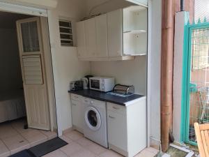 a kitchen with a washing machine and a microwave at HIBISCUS in Le Gosier