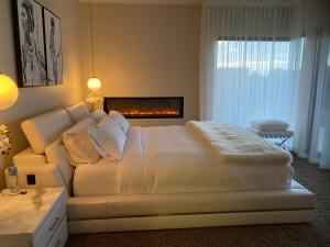 a hotel room with a white bed and a white comforter at Amarè Beachside Luxury in Turners Beach