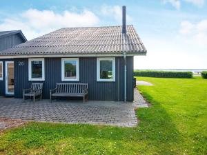 a blue house with two chairs and a bench at 8 person holiday home in Hemmet in Falen